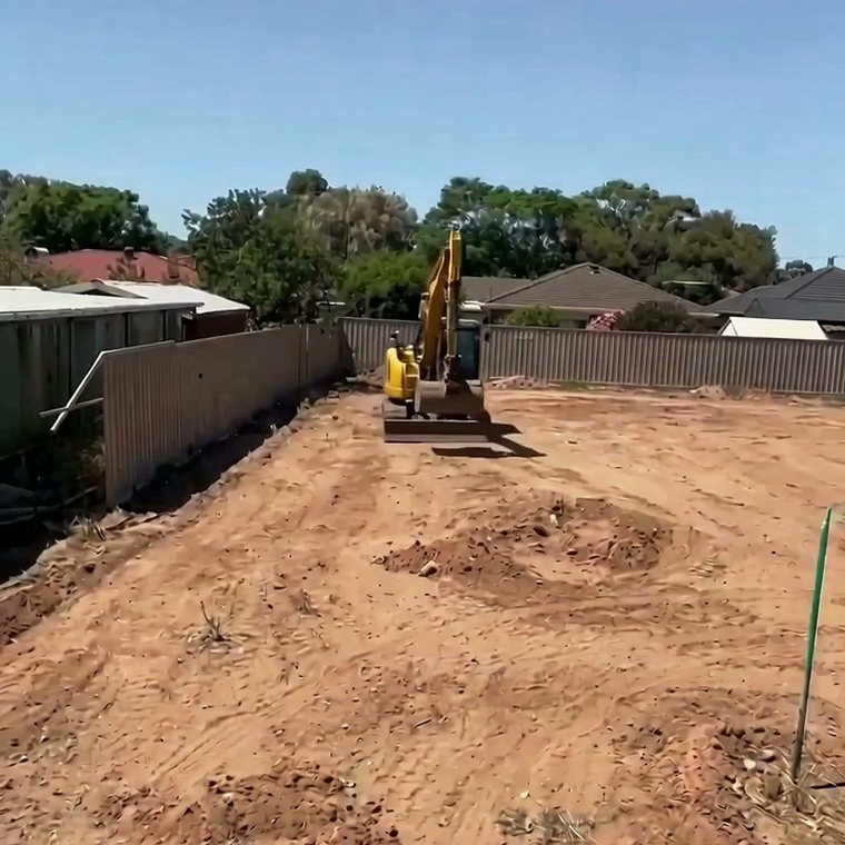 The bare block at Carpenter Road before work started, excavator on site